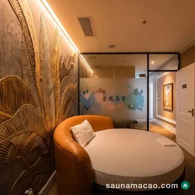金鳳桑拿 — 圓床房，金色棕櫚葉浮雕牆配橙色皮革床圍